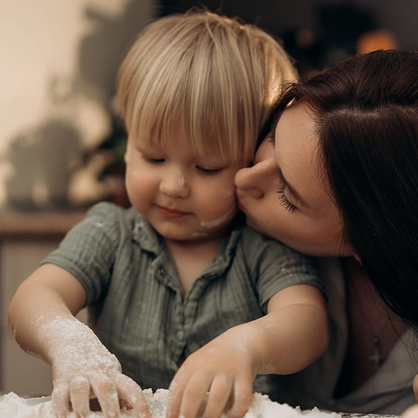 Maminka líbá své dítě během klidné aktivity